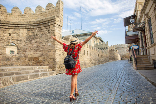 A tourist girl enjoys the charm of Baku's Old City on a sunny day.