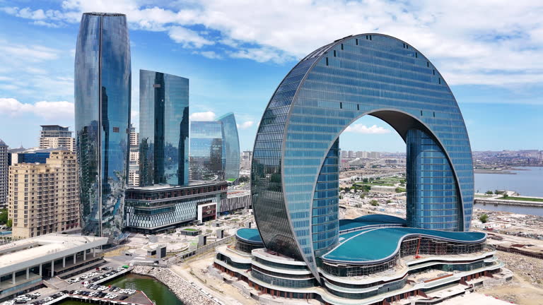 Aerial view of Azerbaijan skyscrappers, Azerbaijan Building of the Crescent Baku Hotel is in shape of a crescent, Crescent Development Project at Sunset Along Caspian Sea Coast Baku, Aerial view of Azerbaijan popular destinations
Azerbaijan, officially the Republic of Azerbaijan, is a transcontinental country located at the boundary of Eastern Europe and West Asia. It is a part of the South Caucasus region and is bounded by the Caspian Sea to the east, Russia's republic of Dagestan to the north, Georgia to the northwest, Armenia and Turkey to the west, and Iran to the south. Baku is the capital and largest city.
