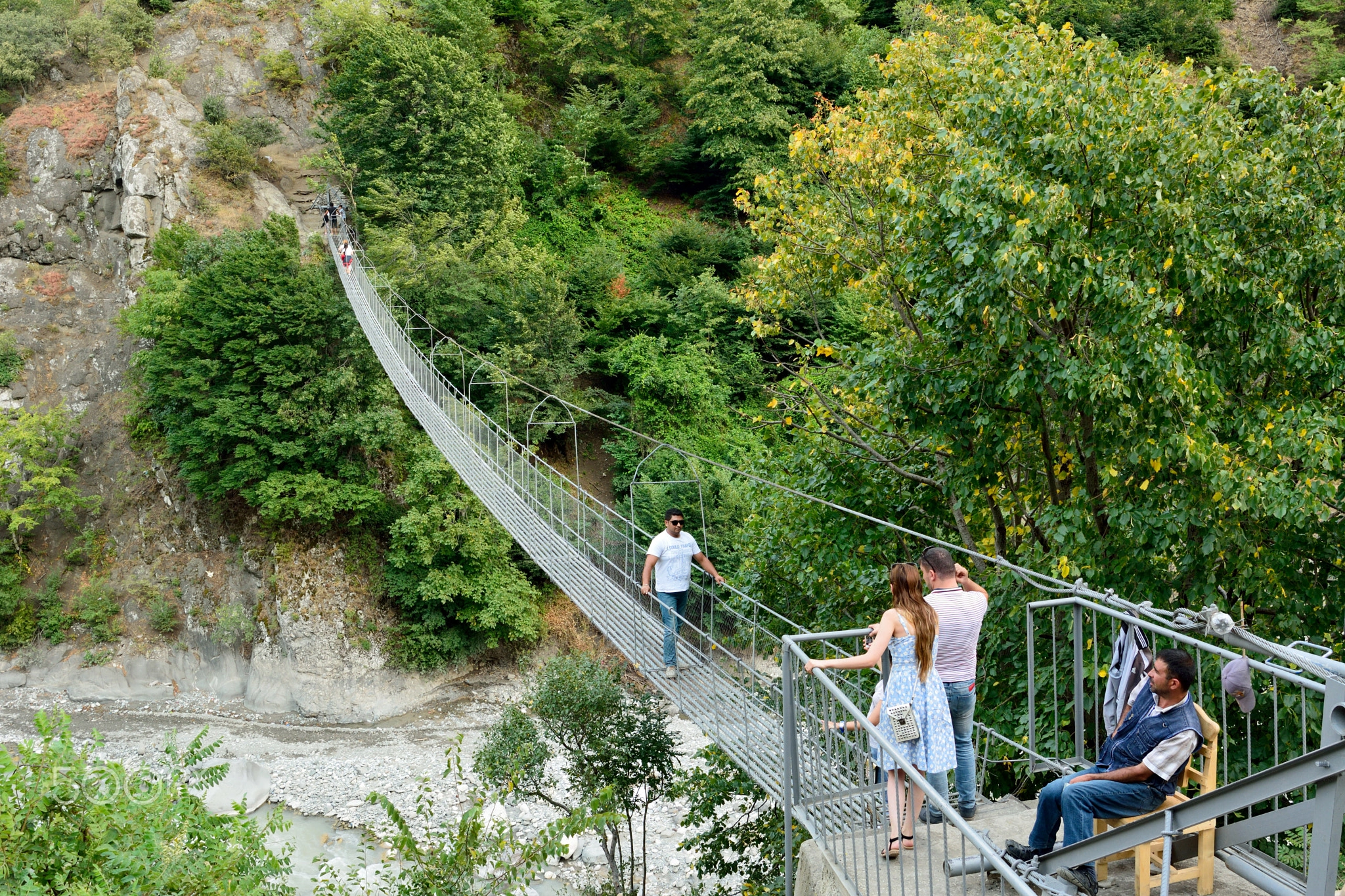 The iconic Zarnava Hanging Bridge, connecting paths across a dramatic mountain canyon.